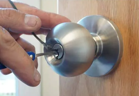 A person is locking the door knob with keys.